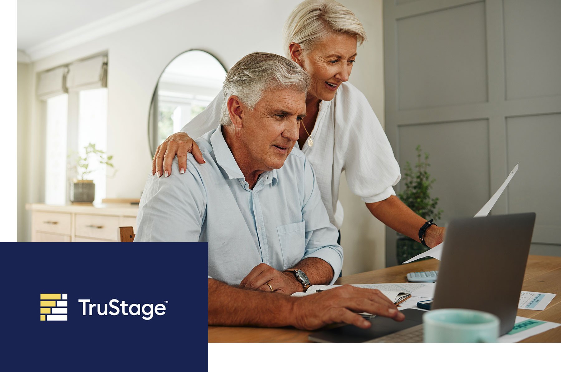 Couple looking at a laptop together. The TruStage logo is in the lower left corner.